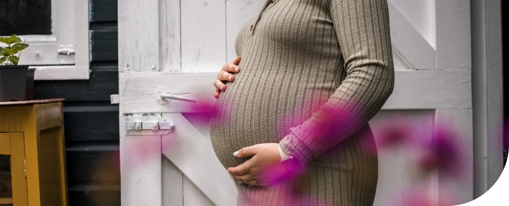 Afbeelding van een zwangere vrouw met wat bloemen in de voorgrond